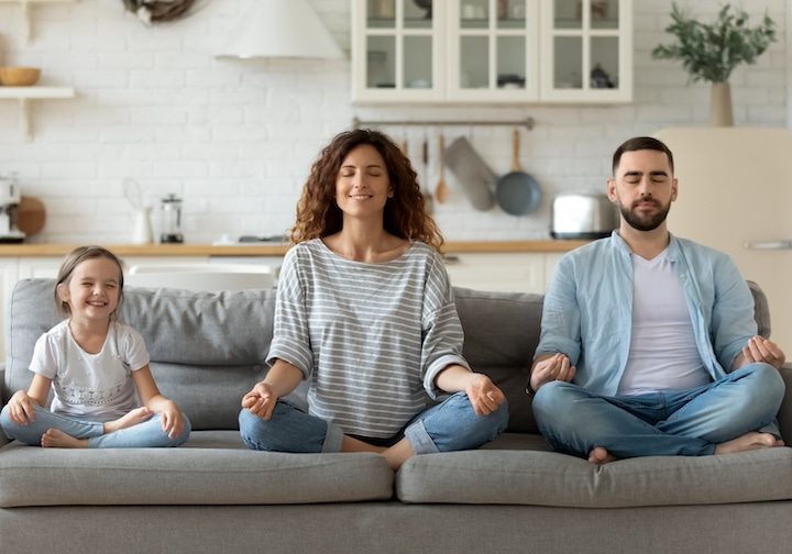 parents with children meditatating on couch with calm children